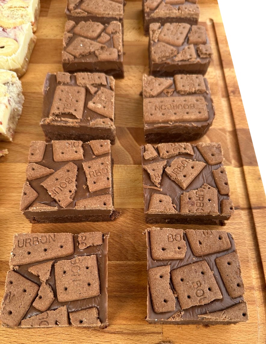 Chocolate fudge squares, each covered with broken bourbon biscuits.