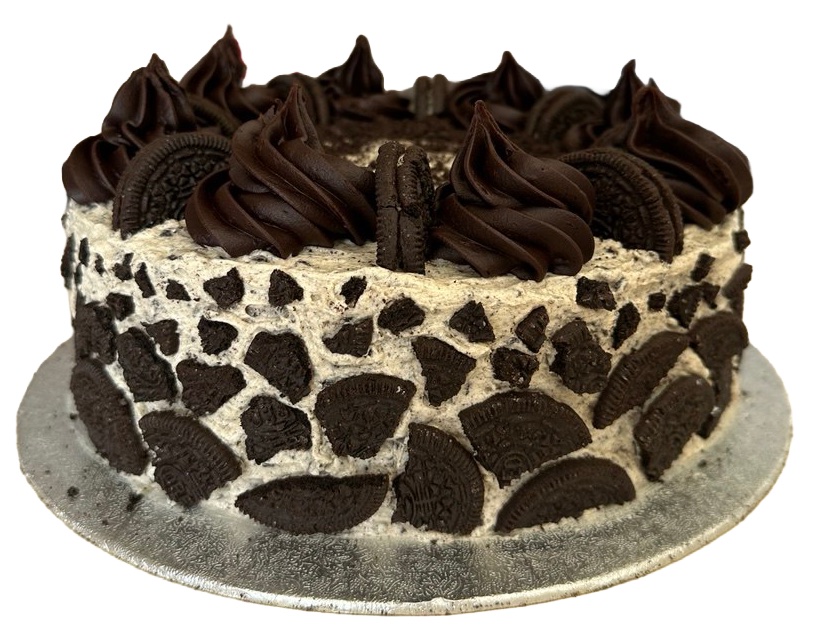 Side view of a cookies-and-cream cake, with pale frosting studded with crushed biscuits and a ring of dark chocolate swirls on top.