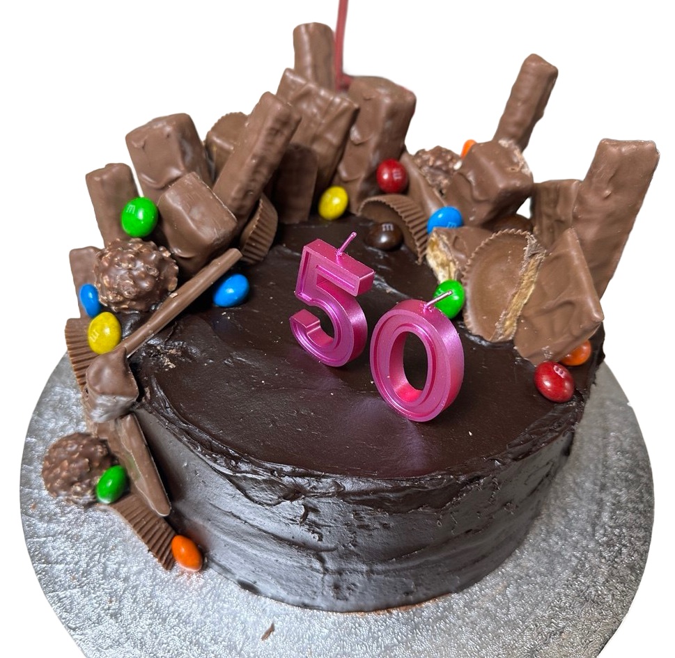 Overhead view of the chocolate fiftieth, with pink 50 candles in the middle and chocolate bars standing around the edge.