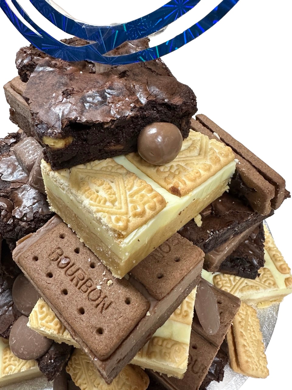 The top of a brownie and biscuit stack, with a blue looped topper, a malt ball, and a custard cream bar.